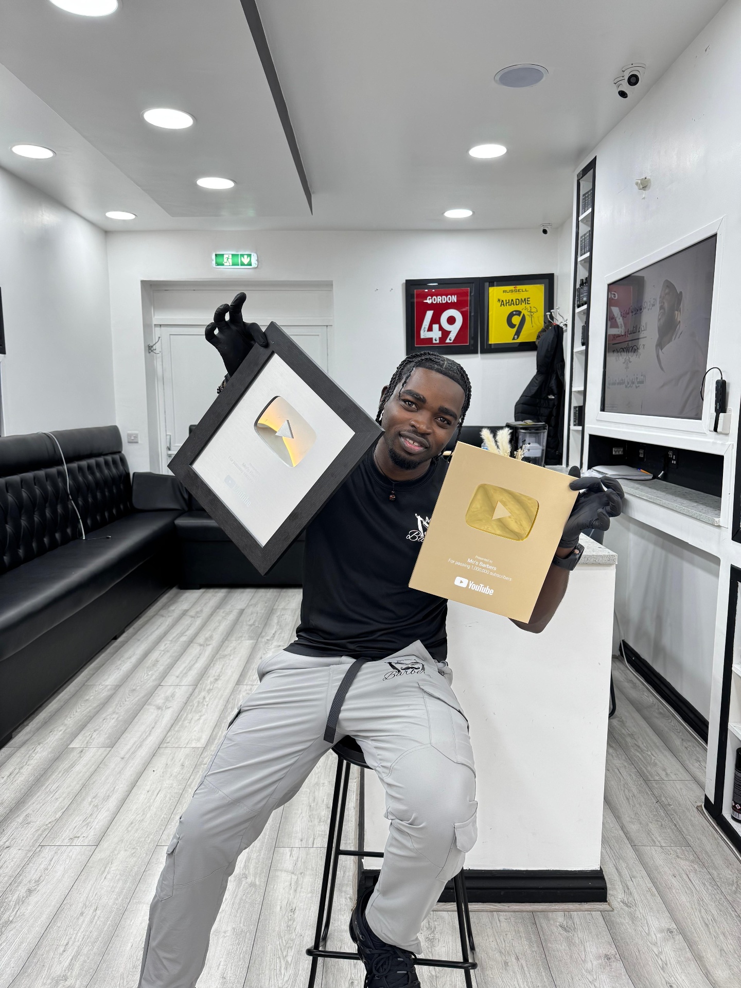 Mo, founder of Mo's Barbers, sitting in his shop